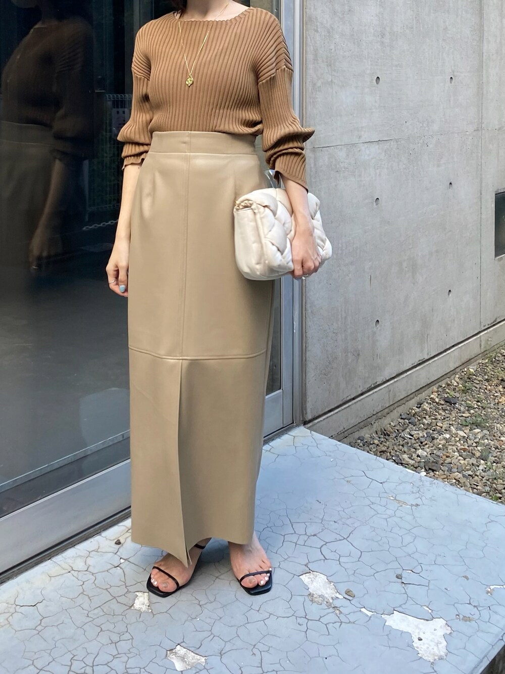 ホワイト系のショルダーバッグ、ベージュ系のスカートを着用したレディースの秋コーディネートの2枚目の写真