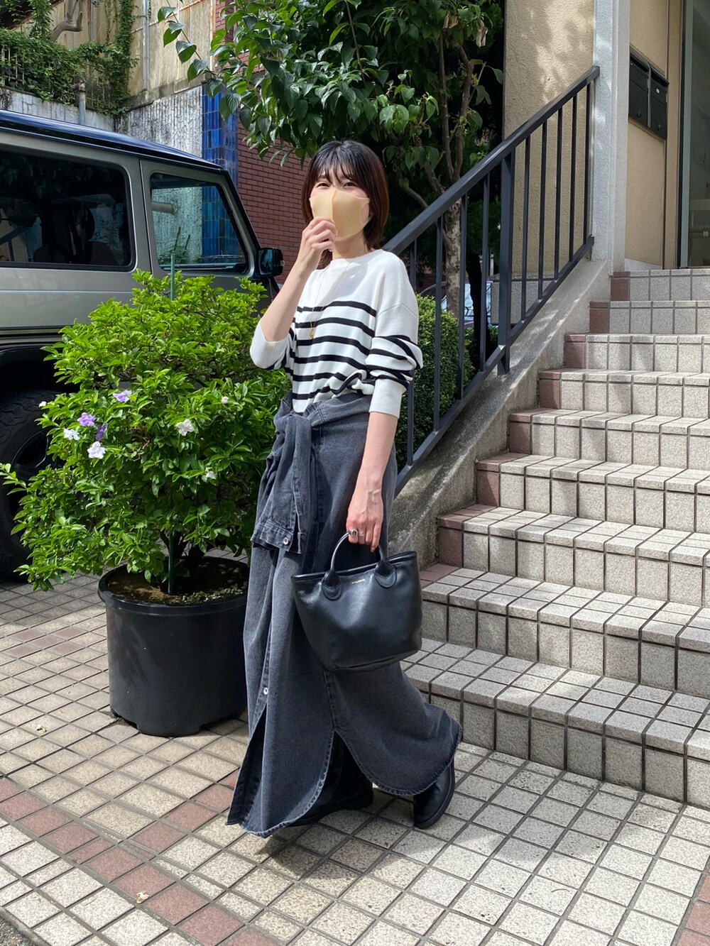 ホワイト系のニット/セーター、ブラック系のシャツワンピース、ブラック系のブーツを着用したレディースの夏コーディネートの2枚目の写真