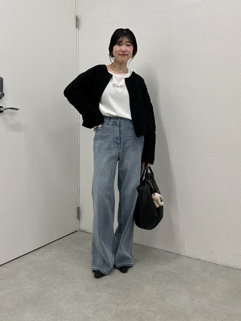 ブルー系のデニムパンツ、ブラック系のカーディガン/ボレロ、ホワイト系のシャツ/ブラウスを着用したレディースの秋コーディネートの4枚目の写真