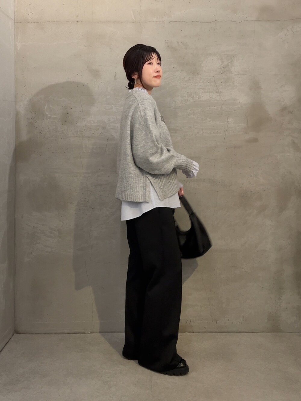 ブルー系のシャツ/ブラウス、グレー系のニット/セーター、ブラック系のその他パンツを着用したレディースの秋コーディネートの3枚目の写真