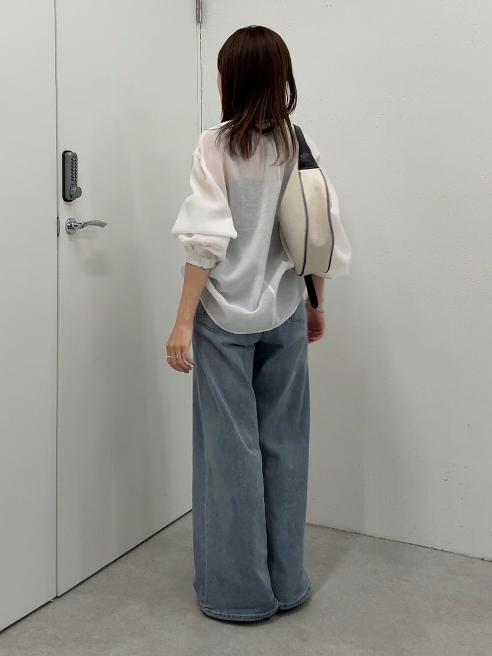 ホワイト系のシャツ/ブラウス、ブルー系のデニムパンツ、ブラック系のショルダーバッグを着用したレディースの春コーディネートの3枚目の写真
