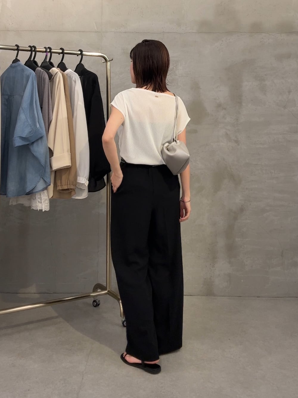 ホワイト系のTシャツ/カットソー、ブラック系のスラックス、シルバー系のネックレスを着用したレディースの春コーディネートの3枚目の写真