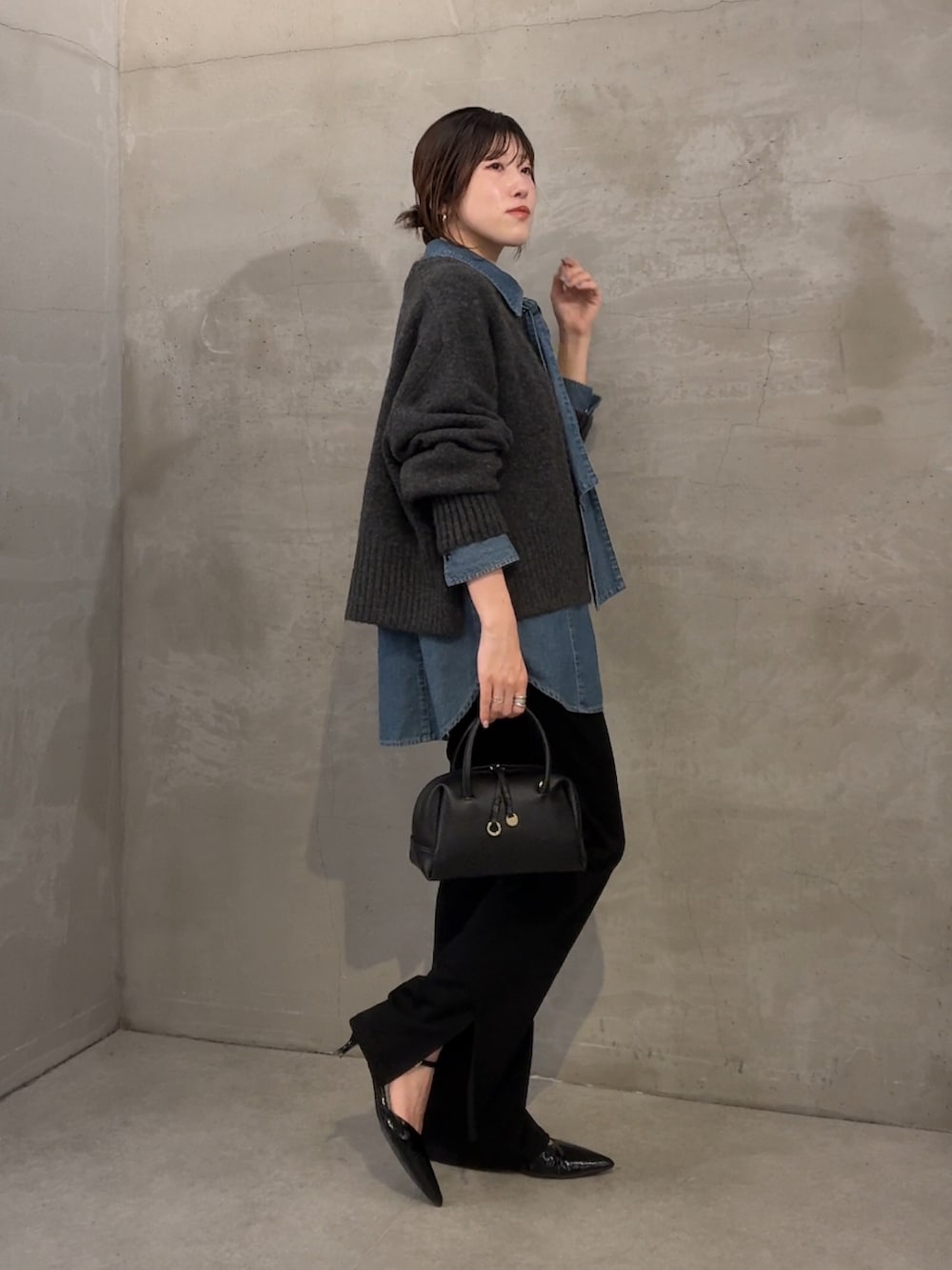 グレー系のニット/セーター、ブルー系のシャツ/ブラウス、ブラック系のその他パンツを着用したレディースの秋コーディネートの2枚目の写真