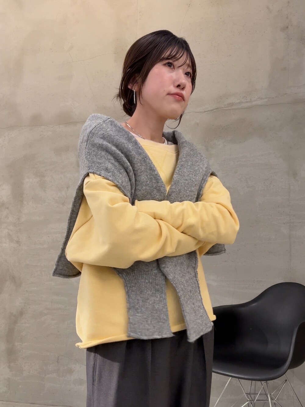 イエロー系のスウェット、ホワイト系のTシャツ/カットソー、グレー系のスラックスを着用したレディースの秋コーディネートの5枚目の写真