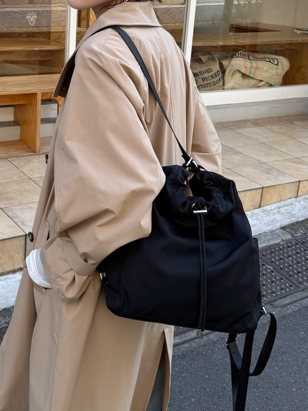 ブラック系のバックパック/リュック、ベージュ系のその他アウター、ブルー系のデニムパンツを着用したレディースの冬コーディネートの3枚目の写真