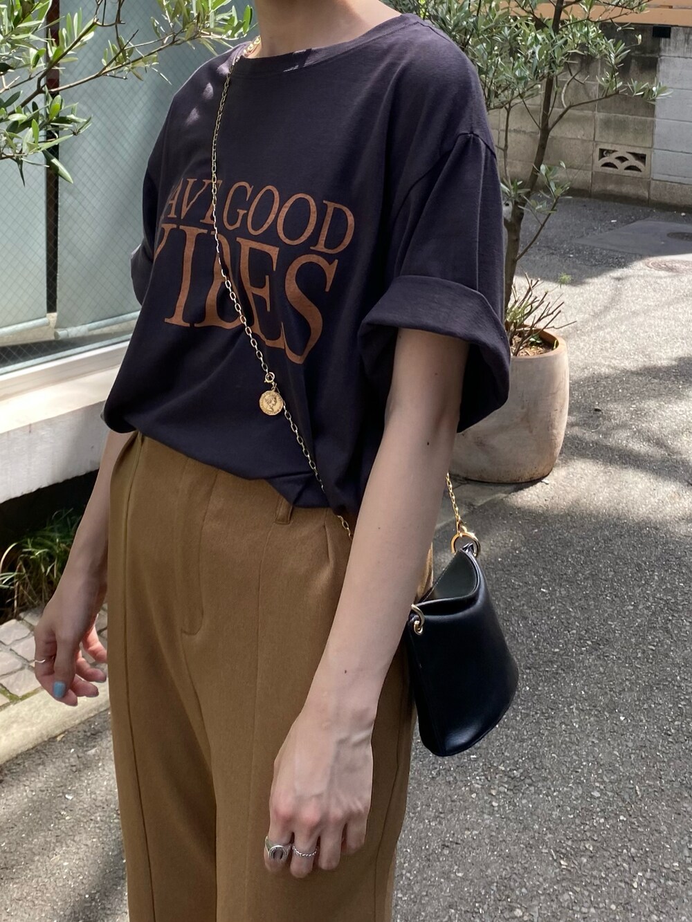 ベージュ系のその他パンツ、グレー系のTシャツ/カットソー、ブラック系のトートバッグを着用したレディースの夏コーディネートの3枚目の写真
