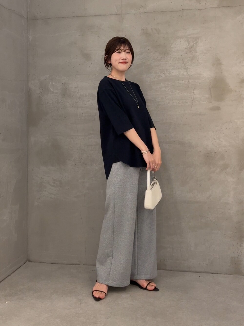 ブルー系のTシャツ/カットソー、グレー系のデニムパンツ、ホワイト系のショルダーバッグを着用したレディースの春コーディネートの4枚目の写真