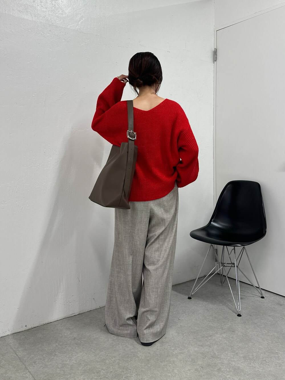 レッド系のニット/セーター、ベージュ系のその他パンツ、ブラウン系のバッグを着用したレディースの秋コーディネートの3枚目の写真