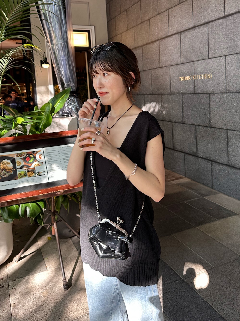 ブラック系のニット/セーター、ブルー系のデニムパンツ、ブラック系のシューズを着用したレディースの春コーディネートの2枚目の写真