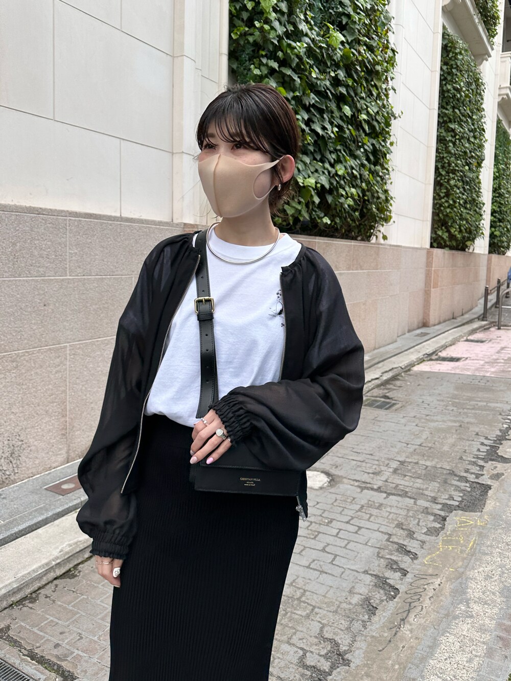 ホワイト系のTシャツ/カットソー、ブラック系のスカート、ブラック系のブルゾンを着用したレディースの春コーディネートの2枚目の写真