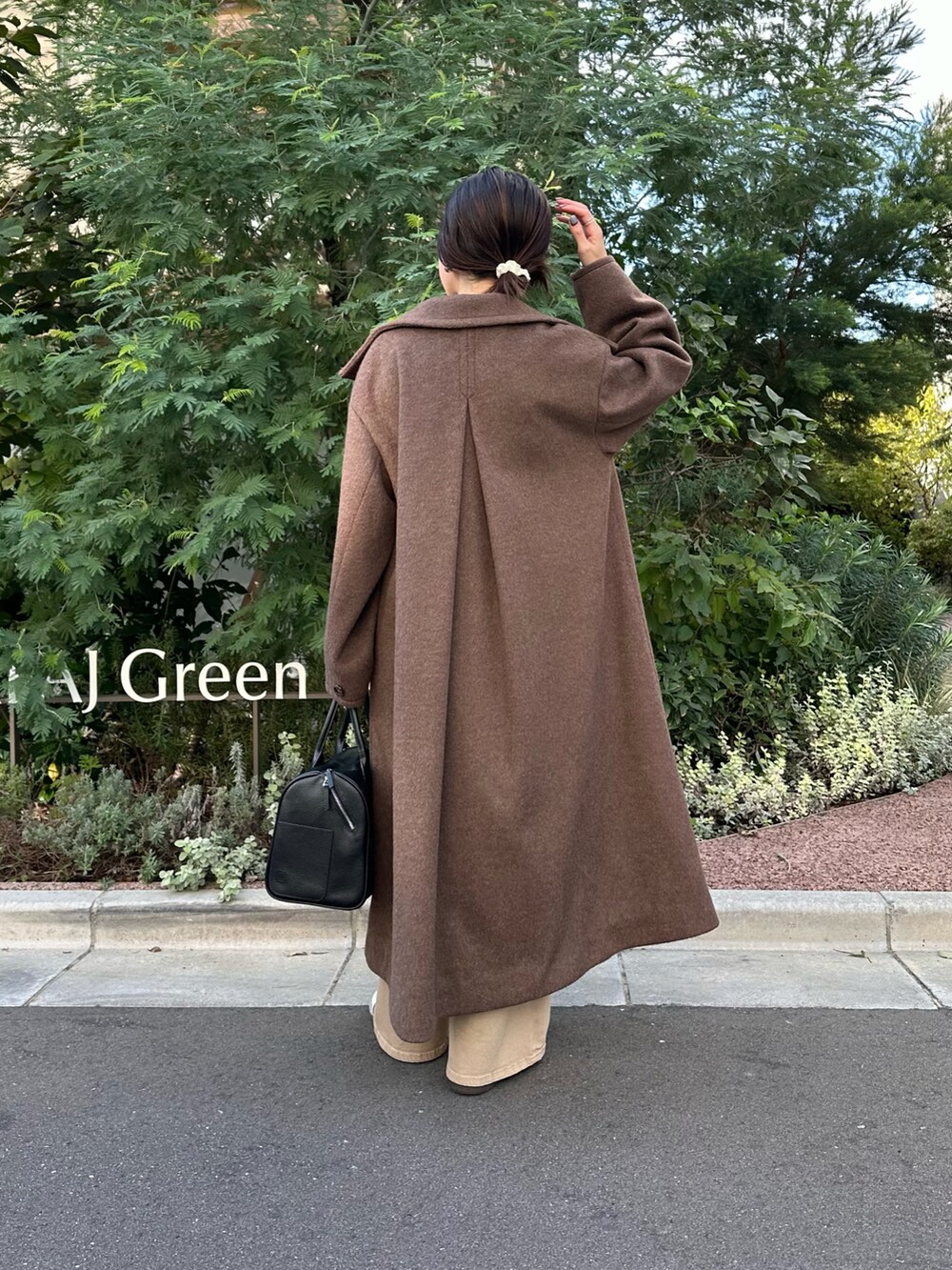 ブラック系のボストンバッグ、グレー系のその他アウター、ブルー系のデニムパンツを着用したレディースの秋コーディネートの5枚目の写真