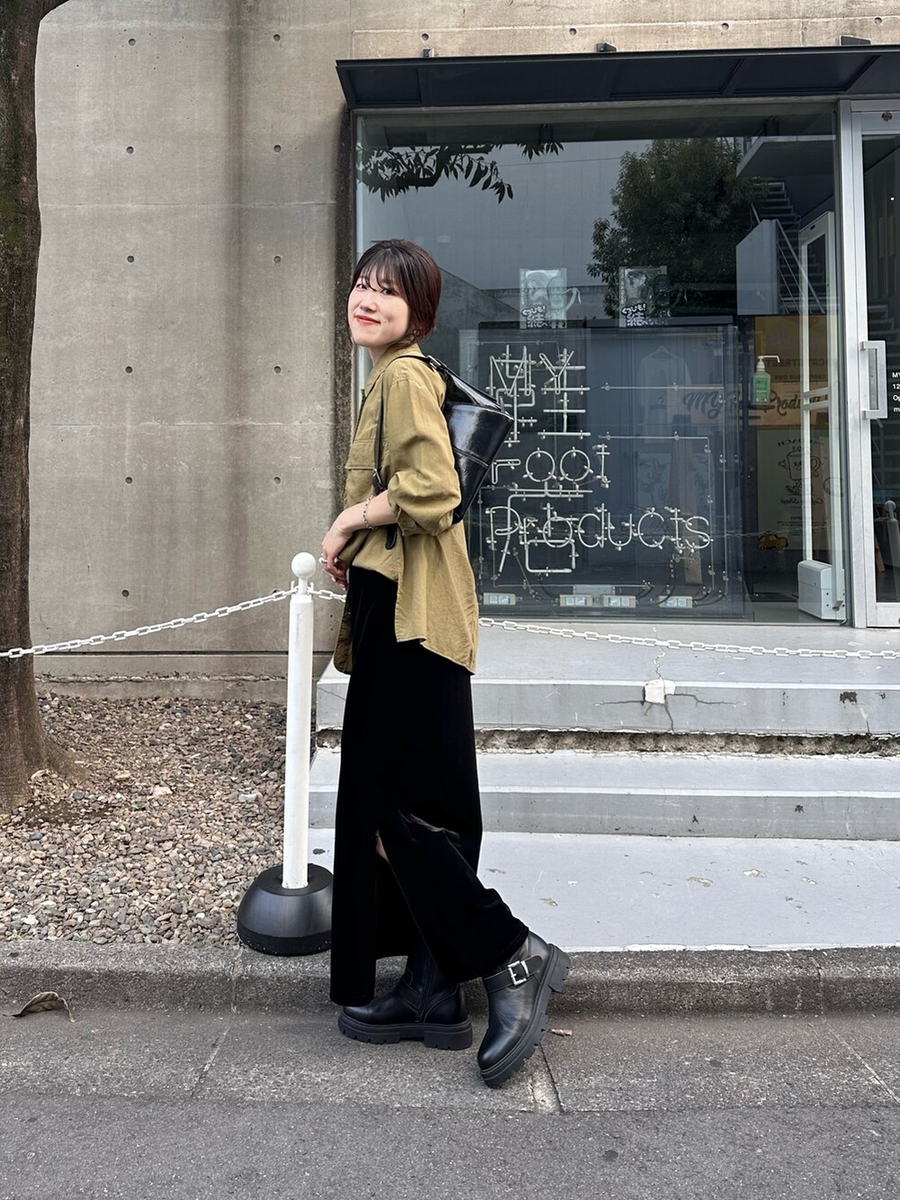 グリーン系のシャツ/ブラウス、ブラック系のスカート、ブラック系のバッグを着用したレディースの秋コーディネートの4枚目の写真