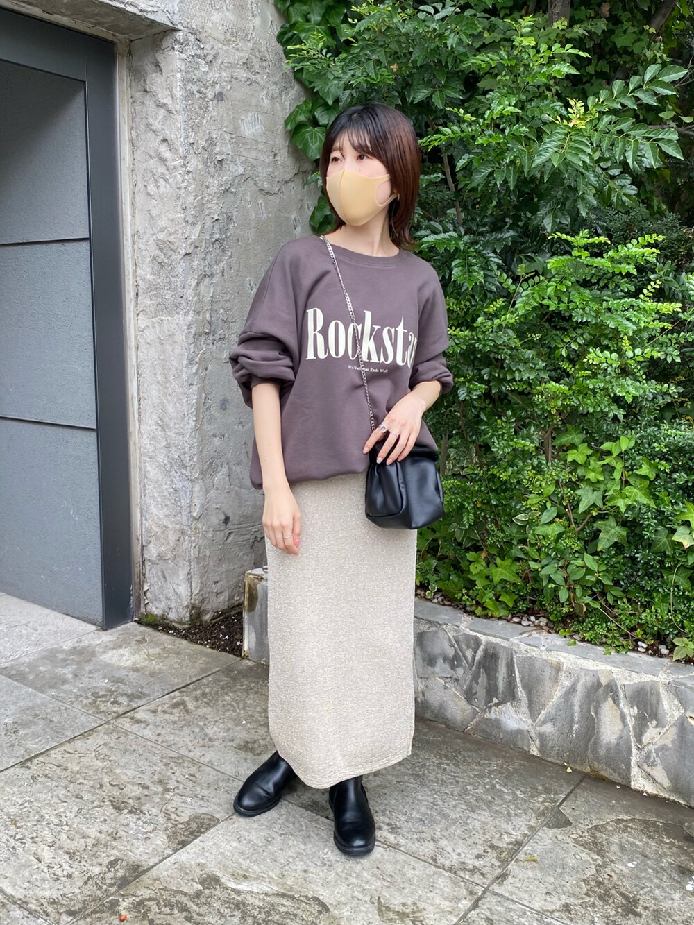 グレー系のスウェット、ゴールド系のスカート、ブラック系のショルダーバッグを着用したレディースの夏コーディネートの5枚目の写真