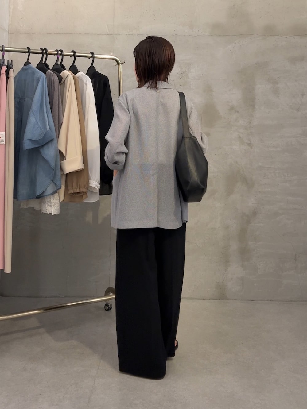 グレー系のテーラードジャケット、ホワイト系のTシャツ/カットソー、ブラック系のスラックスを着用したレディースの春コーディネートの2枚目の写真