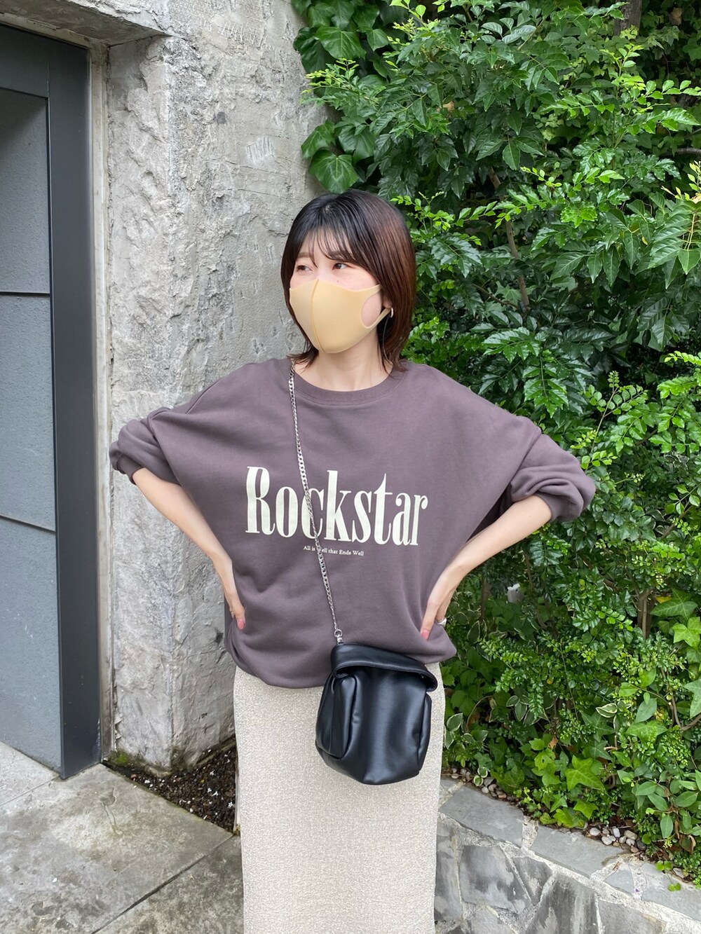 グレー系のスウェット、ゴールド系のスカート、ブラック系のショルダーバッグを着用したレディースの夏コーディネートの4枚目の写真