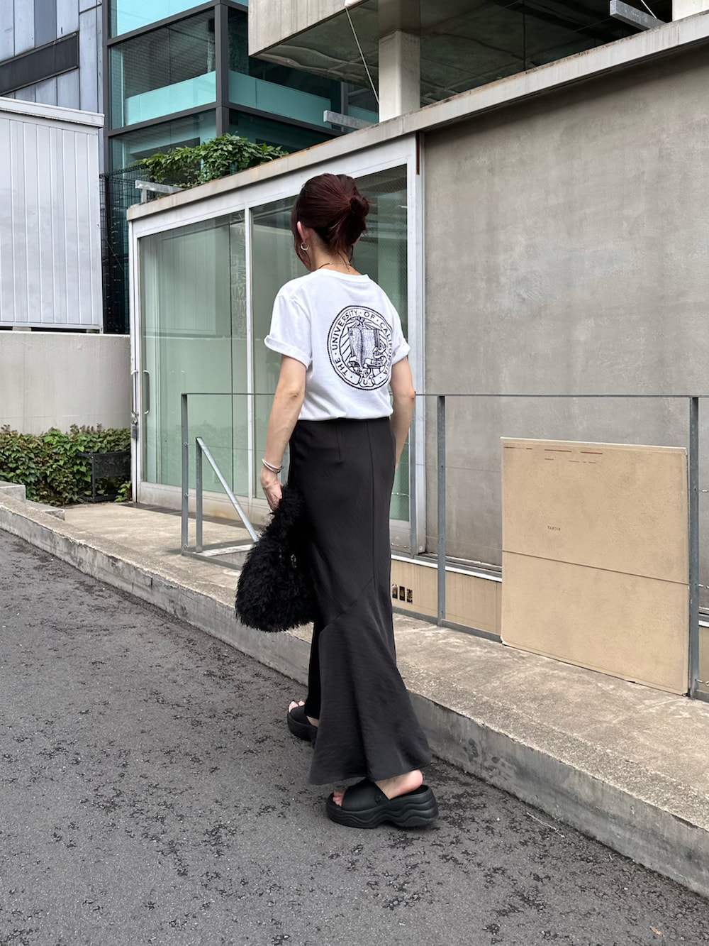 ホワイト系のTシャツ/カットソー、ブラック系のバッグ、ブラック系のスカートを着用したレディースの夏コーディネートの2枚目の写真