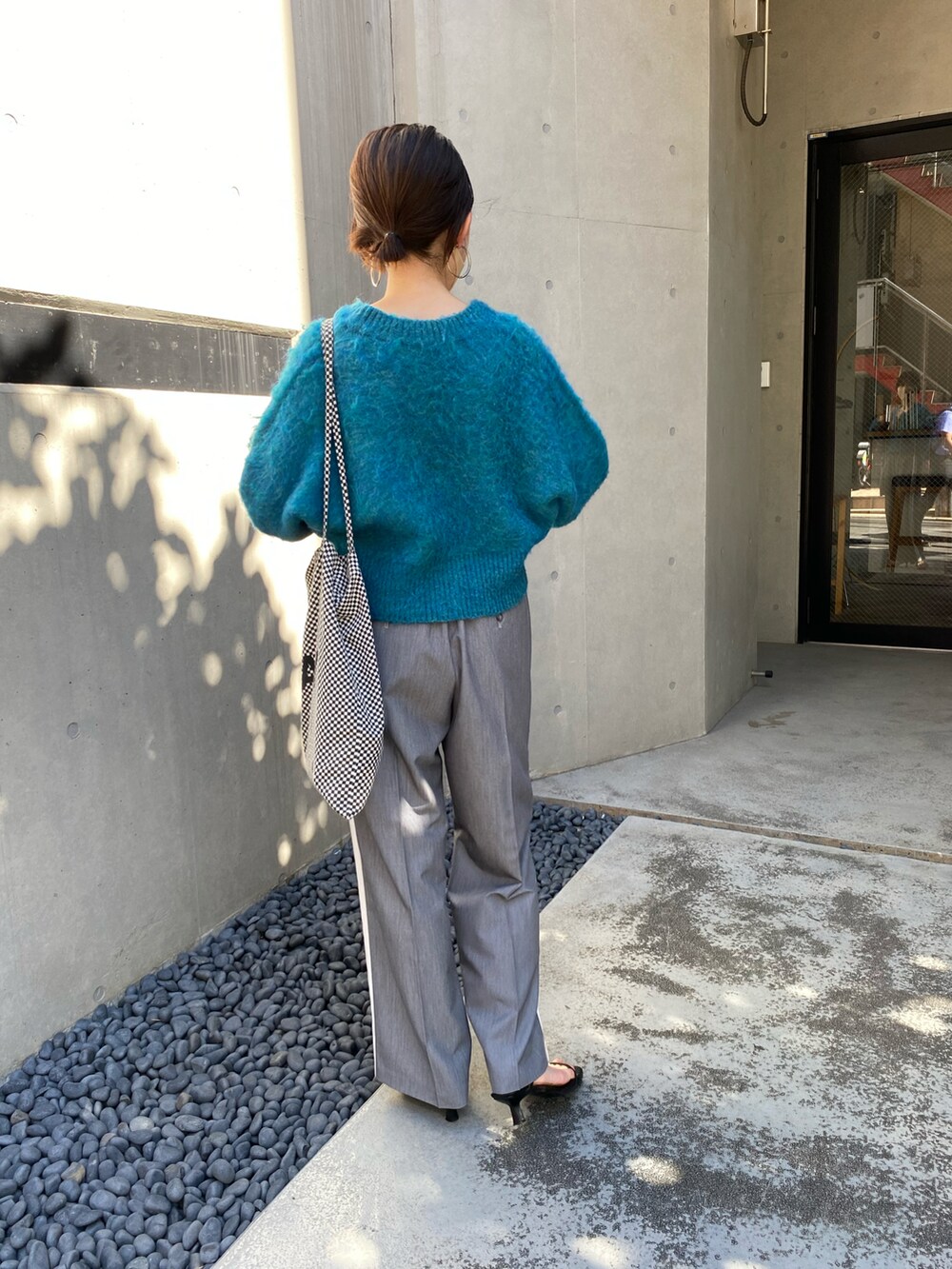 ブルー系のカーディガン/ボレロ、グレー系のスラックスを着用したレディースの秋コーディネートの2枚目の写真