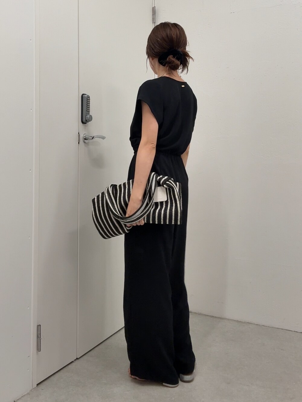 ブラック系のつなぎ/オールインワン、ブラック系のトートバッグ、ゴールド系のネックレスを着用したレディースの春コーディネートの3枚目の写真