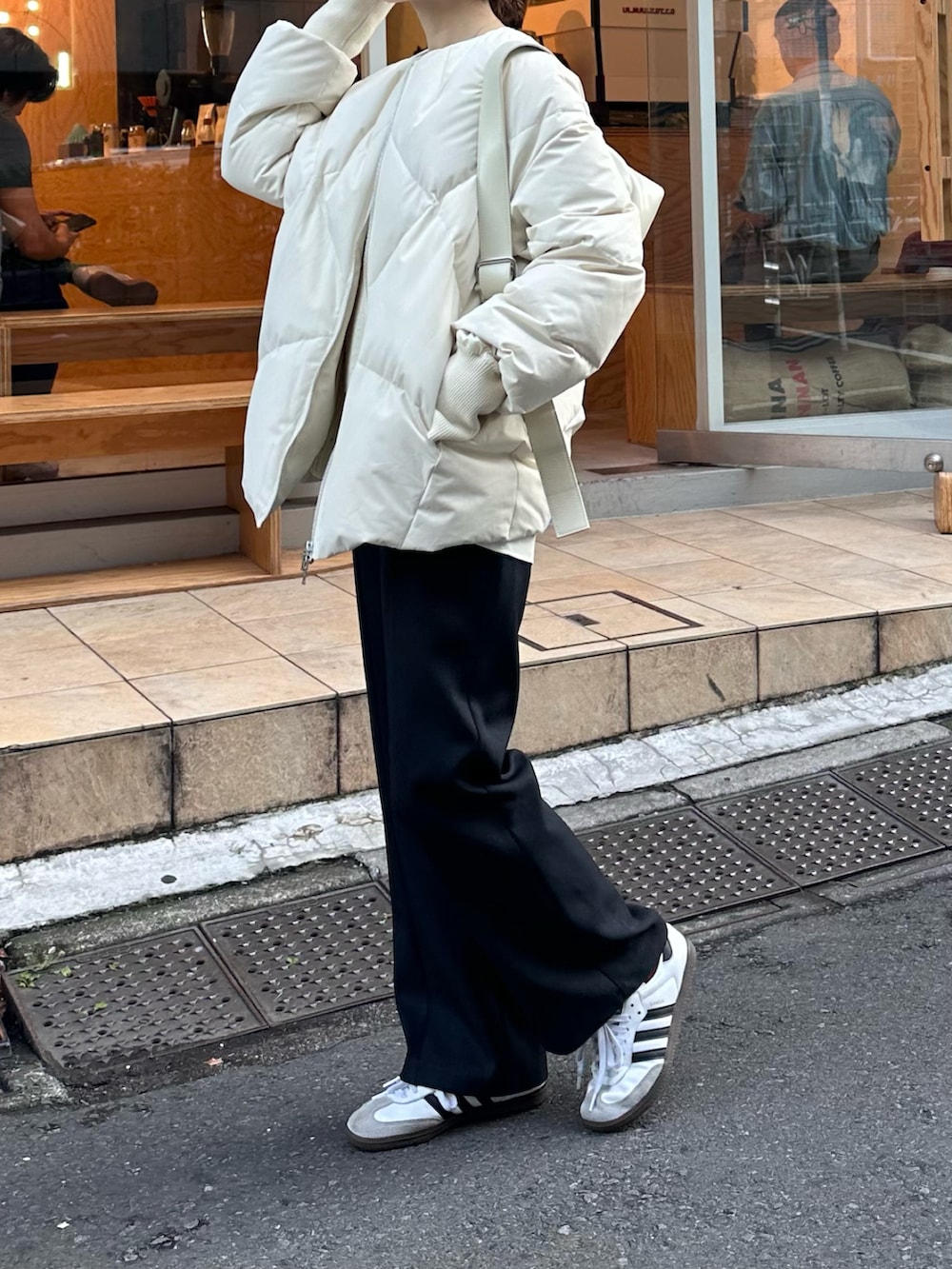 ホワイト系のニット/セーター、ブルー系のスラックス、ホワイト系のシャツ/ブラウスを着用したレディースの冬コーディネートの4枚目の写真