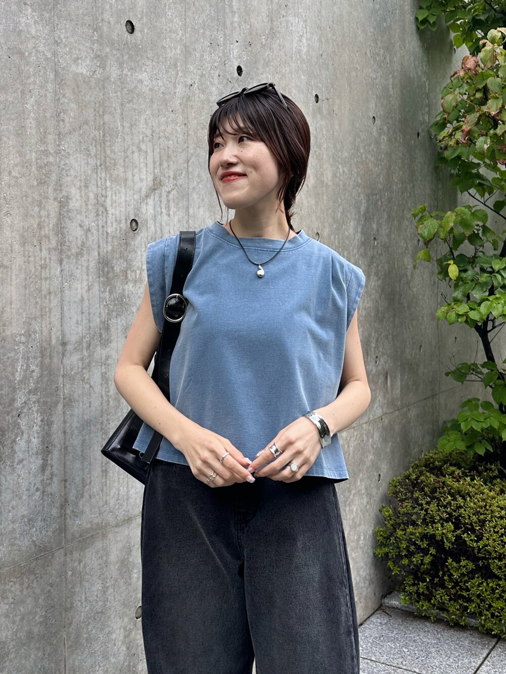 ブルー系のTシャツ/カットソー、ブラック系のデニムパンツ、ブラック系のバッグを着用したレディースの夏コーディネートの4枚目の写真