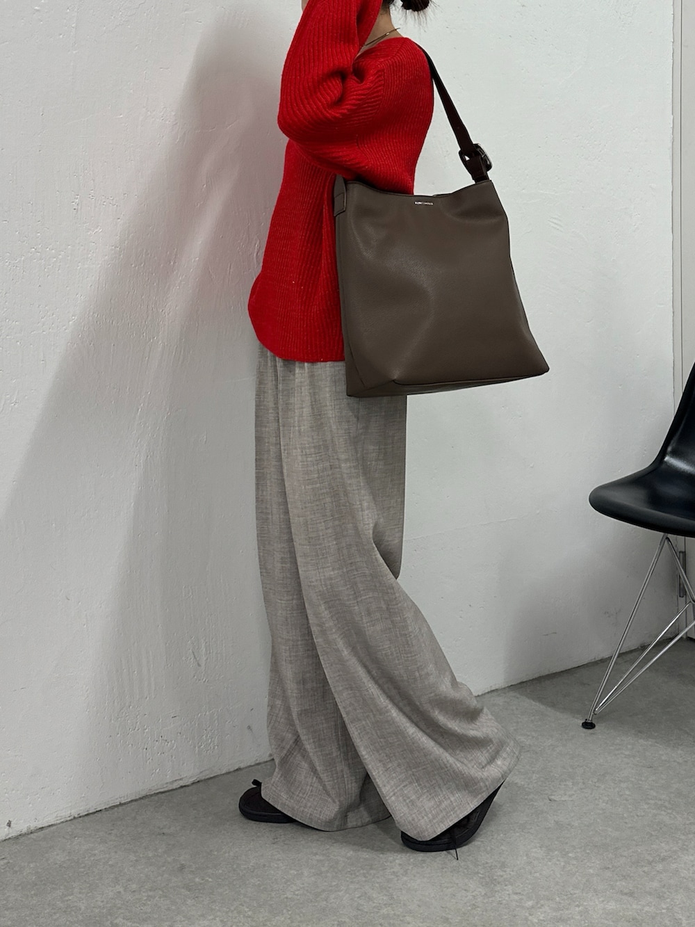 レッド系のニット/セーター、ベージュ系のその他パンツ、ブラウン系のバッグを着用したレディースの秋コーディネートの4枚目の写真