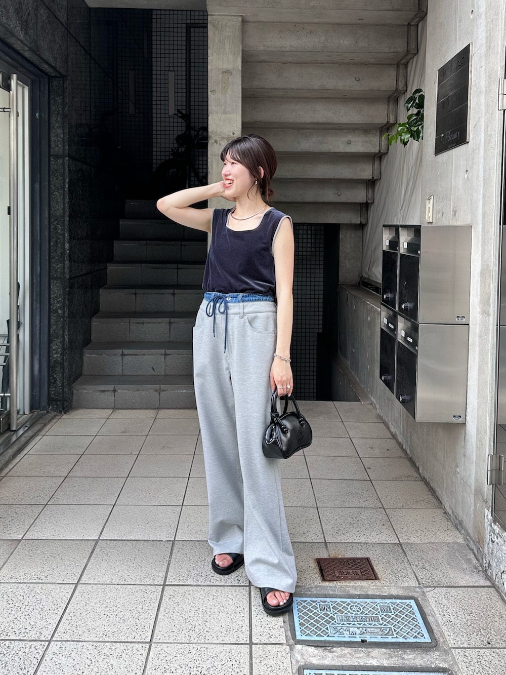 ブルー系のTシャツ/カットソー、グレー系のデニムパンツ、ブラック系のバッグを着用したレディースの夏コーディネートの5枚目の写真