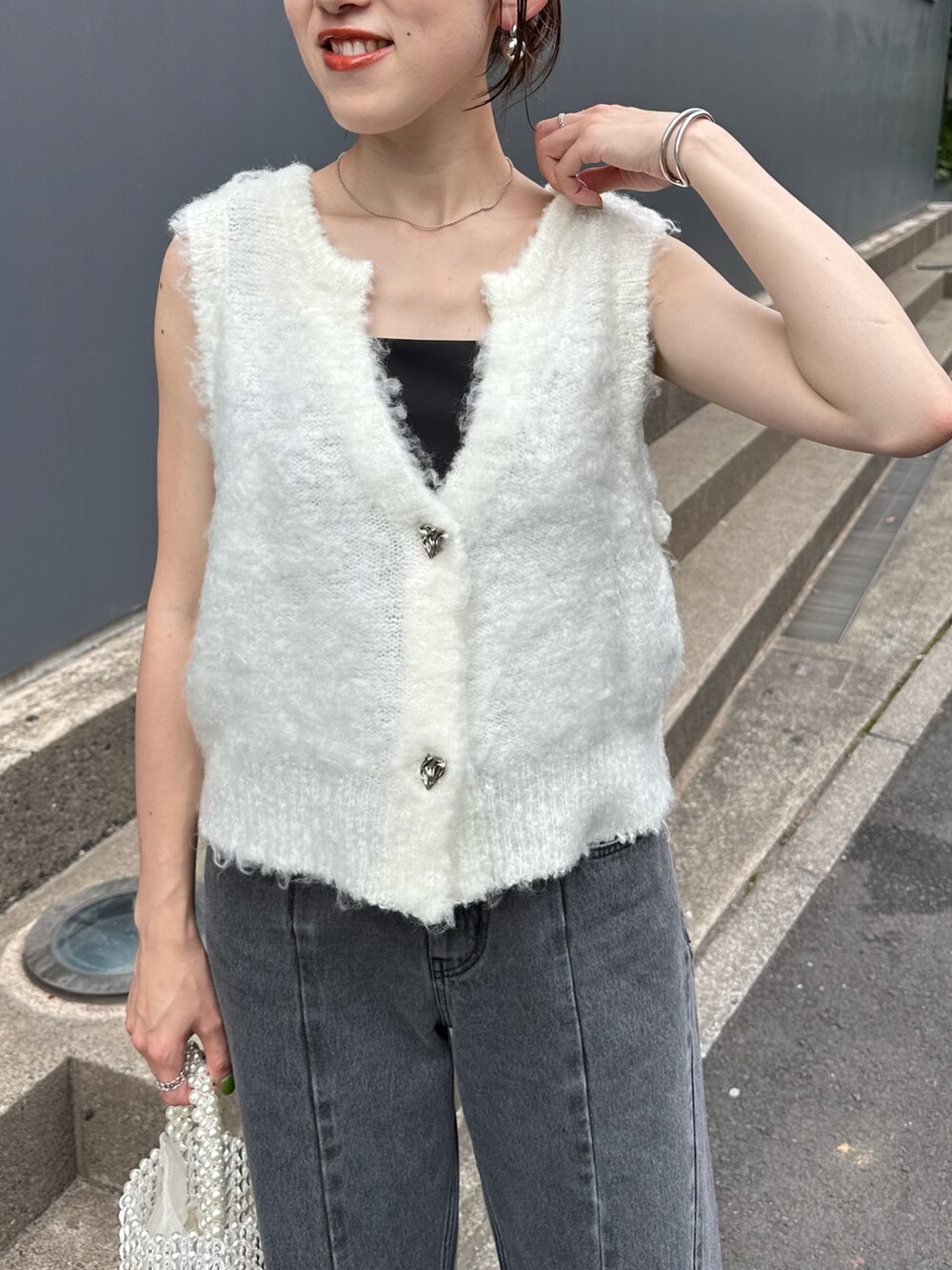 ホワイト系のカーディガン/ボレロ、ブラック系のキャミソール、ブルー系のデニムパンツを着用したレディースの夏コーディネートの2枚目の写真