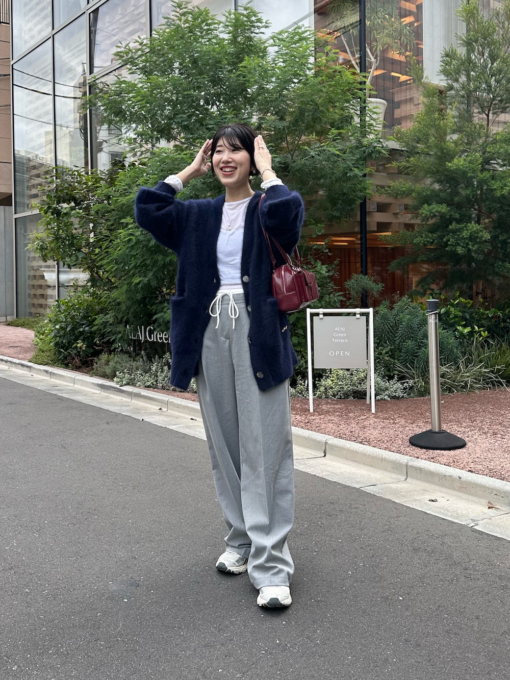 ブルー系のカーディガン/ボレロ、ホワイト系のTシャツ/カットソー、ブラック系のバッグを着用したレディースの秋コーディネートの2枚目の写真