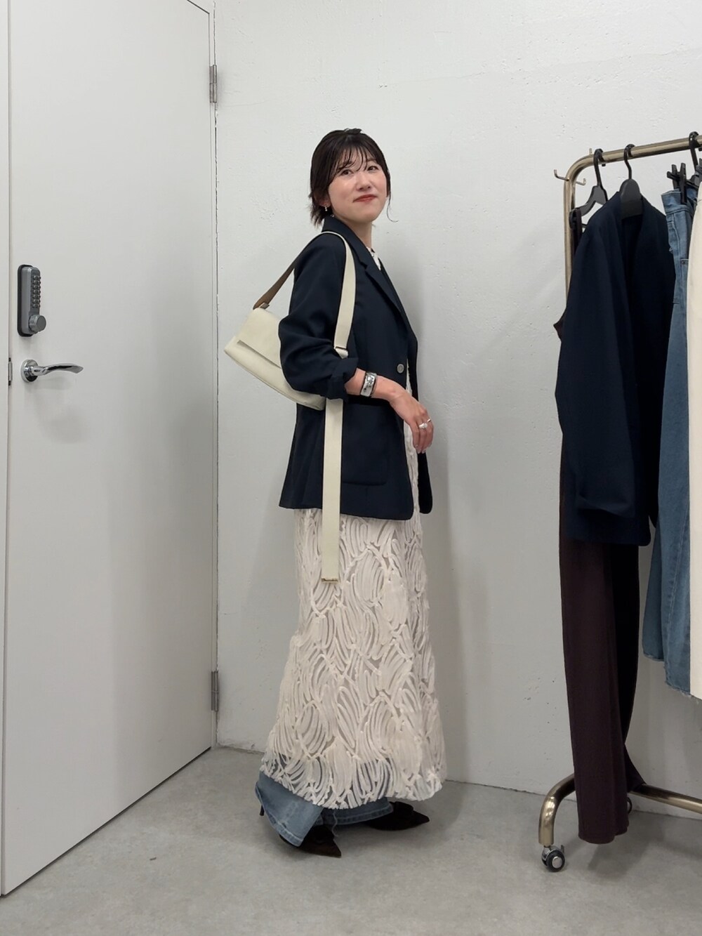 ブルー系のテーラードジャケット、ホワイト系のワンピース/ドレス、ホワイト系のバッグを着用したレディースの春コーディネートの3枚目の写真