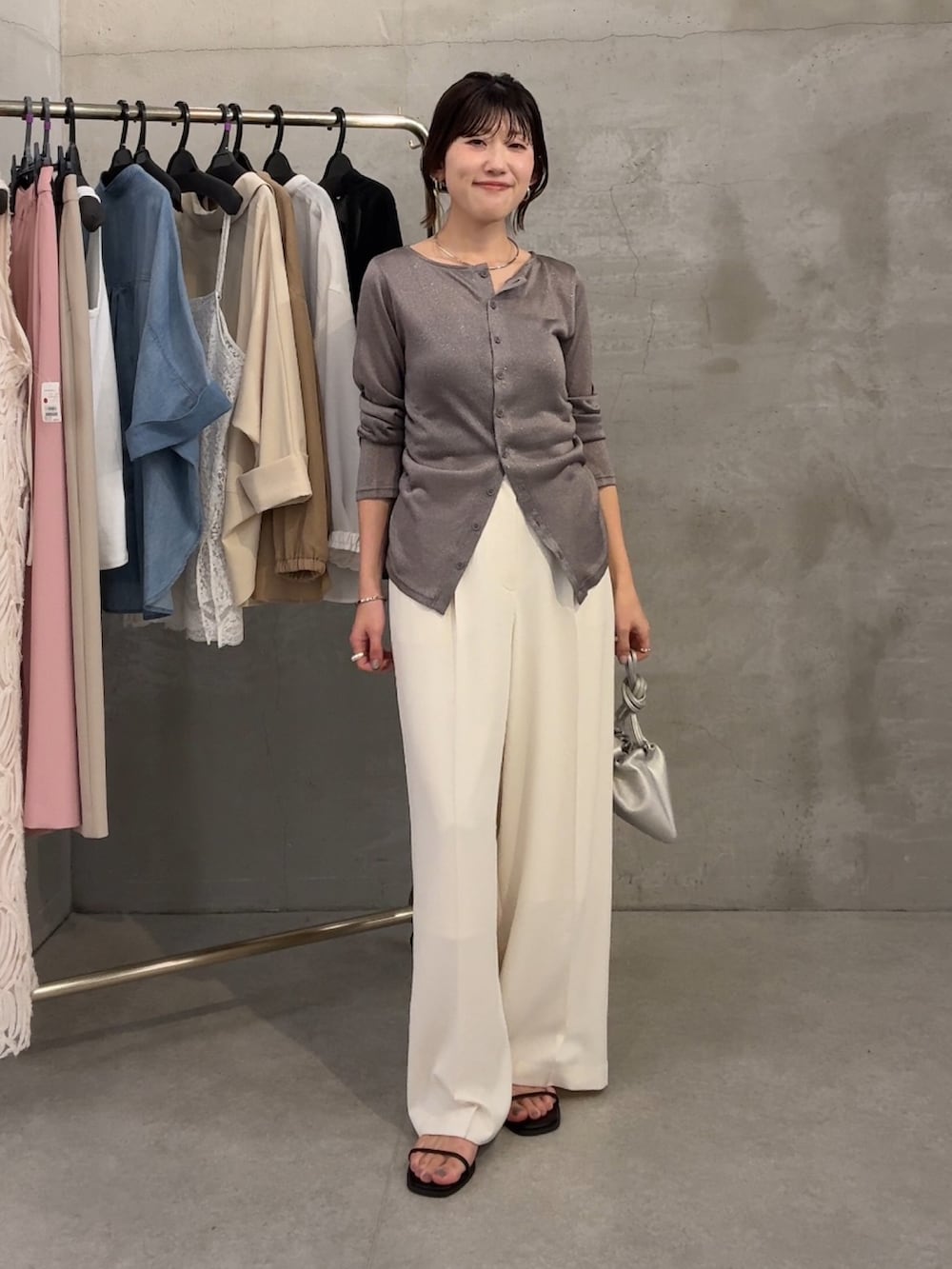 グレー系のカーディガン/ボレロ、ブラック系のサンダル、ホワイト系のスラックスを着用したレディースの春コーディネートの6枚目の写真