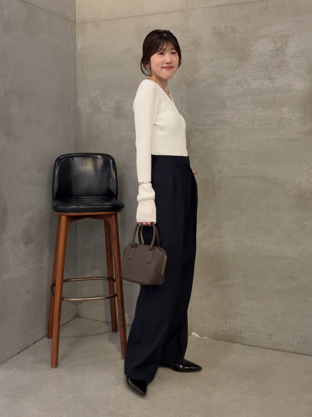 ホワイト系のニット/セーター、ブラウン系のショルダーバッグ、ブルー系のスラックスを着用したレディースの夏コーディネートの2枚目の写真