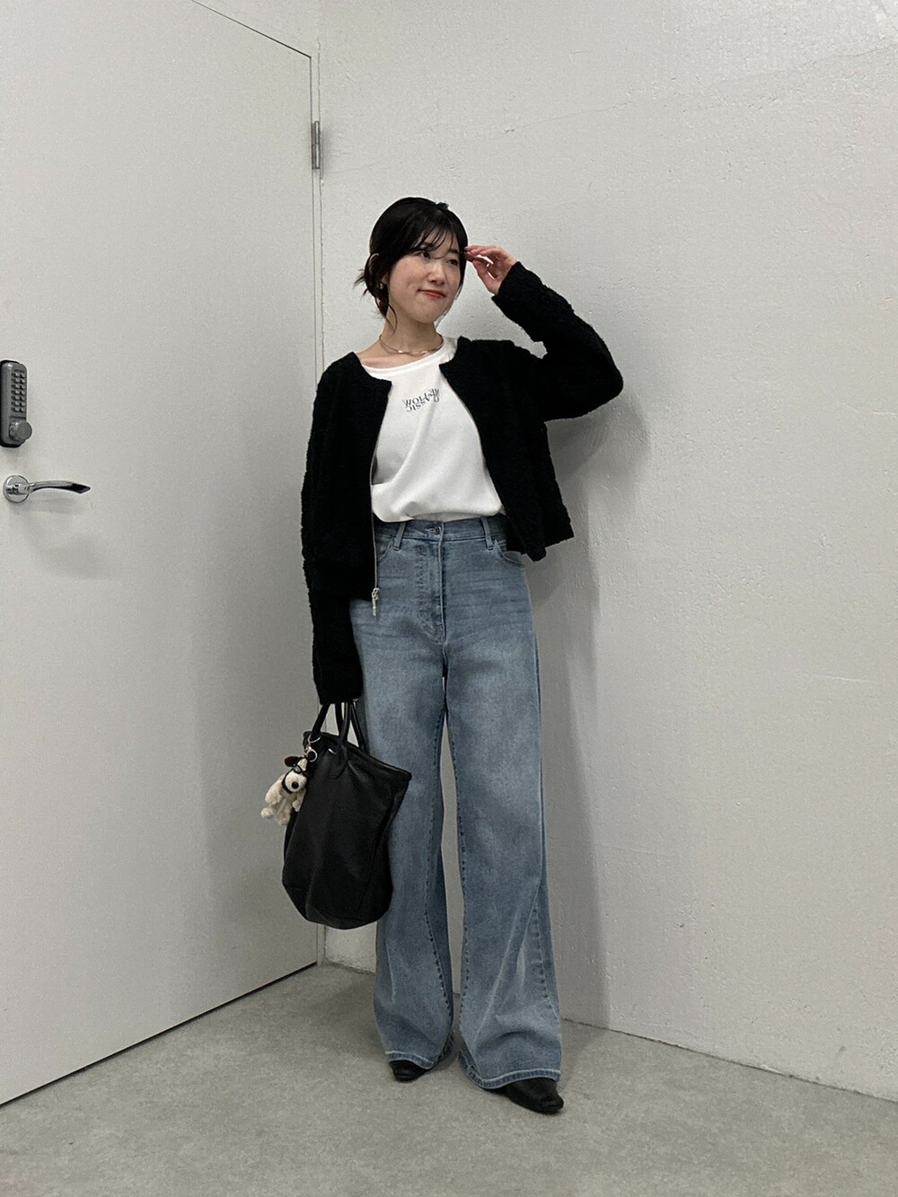 ブラック系のカーディガン/ボレロ、ブルー系のデニムパンツ、ホワイト系のシャツ/ブラウスを着用したレディースの冬コーディネートの4枚目の写真