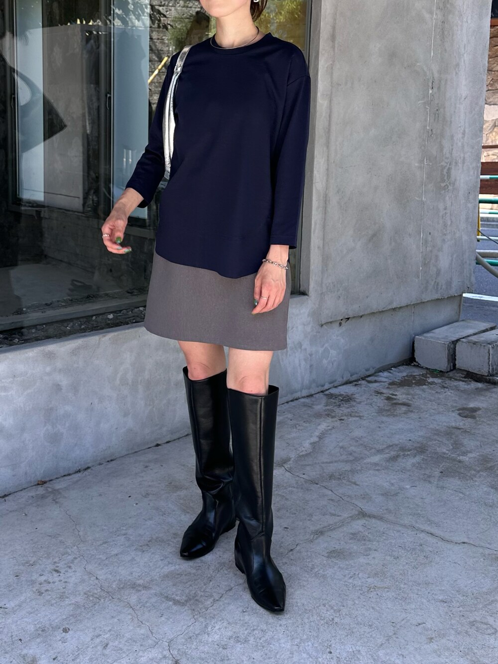 ブルー系のTシャツ/カットソー、グレー系のスカート、ベージュ系のブーツを着用したレディースの夏コーディネートの4枚目の写真