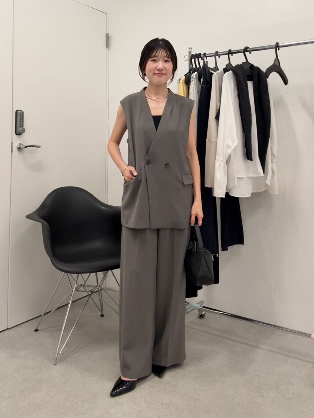 グレー系のセットアップ、ブラック系のパンプスを着用したレディースの秋コーディネートの4枚目の写真