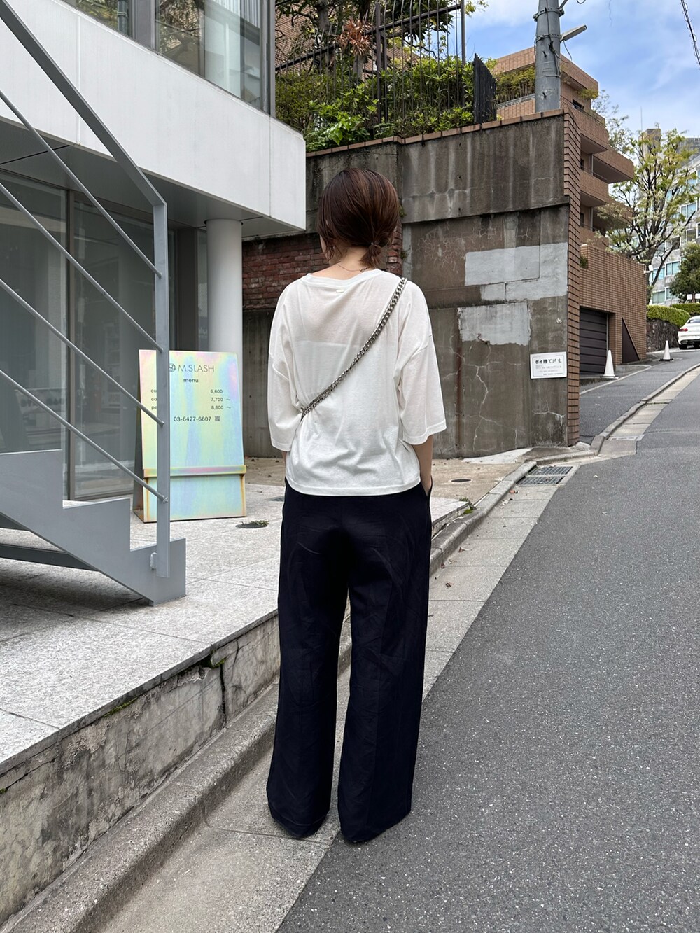 ホワイト系のTシャツ/カットソー、ブラック系のショルダーバッグ、ブルー系のスラックスを着用したレディースの春コーディネートの3枚目の写真