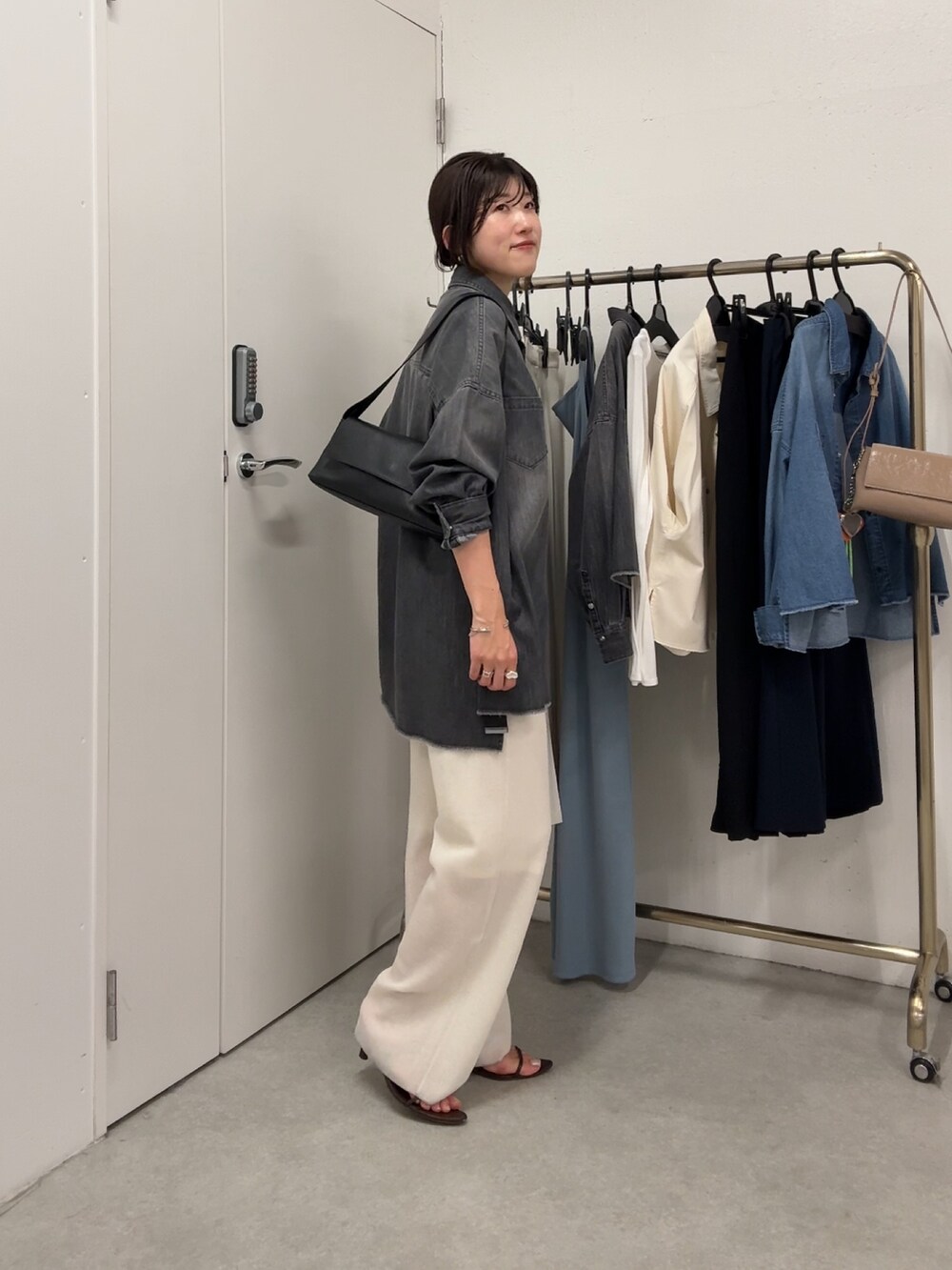 ブラック系のシャツ/ブラウス、ホワイト系のパンツ、ホワイト系のバッグを着用したレディースの春コーディネートの2枚目の写真