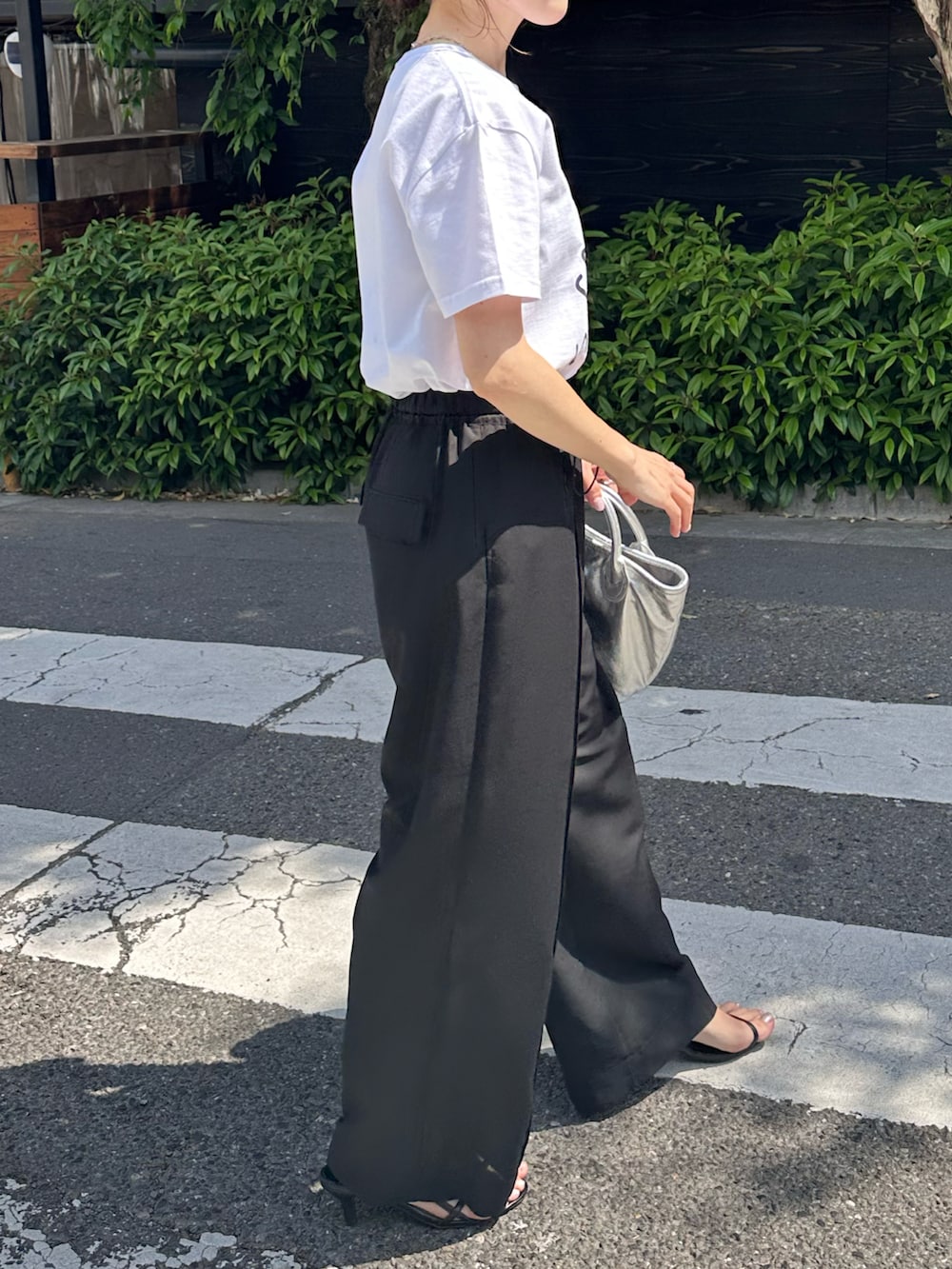 ホワイト系のTシャツ/カットソー、ブラック系のその他パンツ、シルバー系のトートバッグを着用したレディースの春コーディネートの4枚目の写真