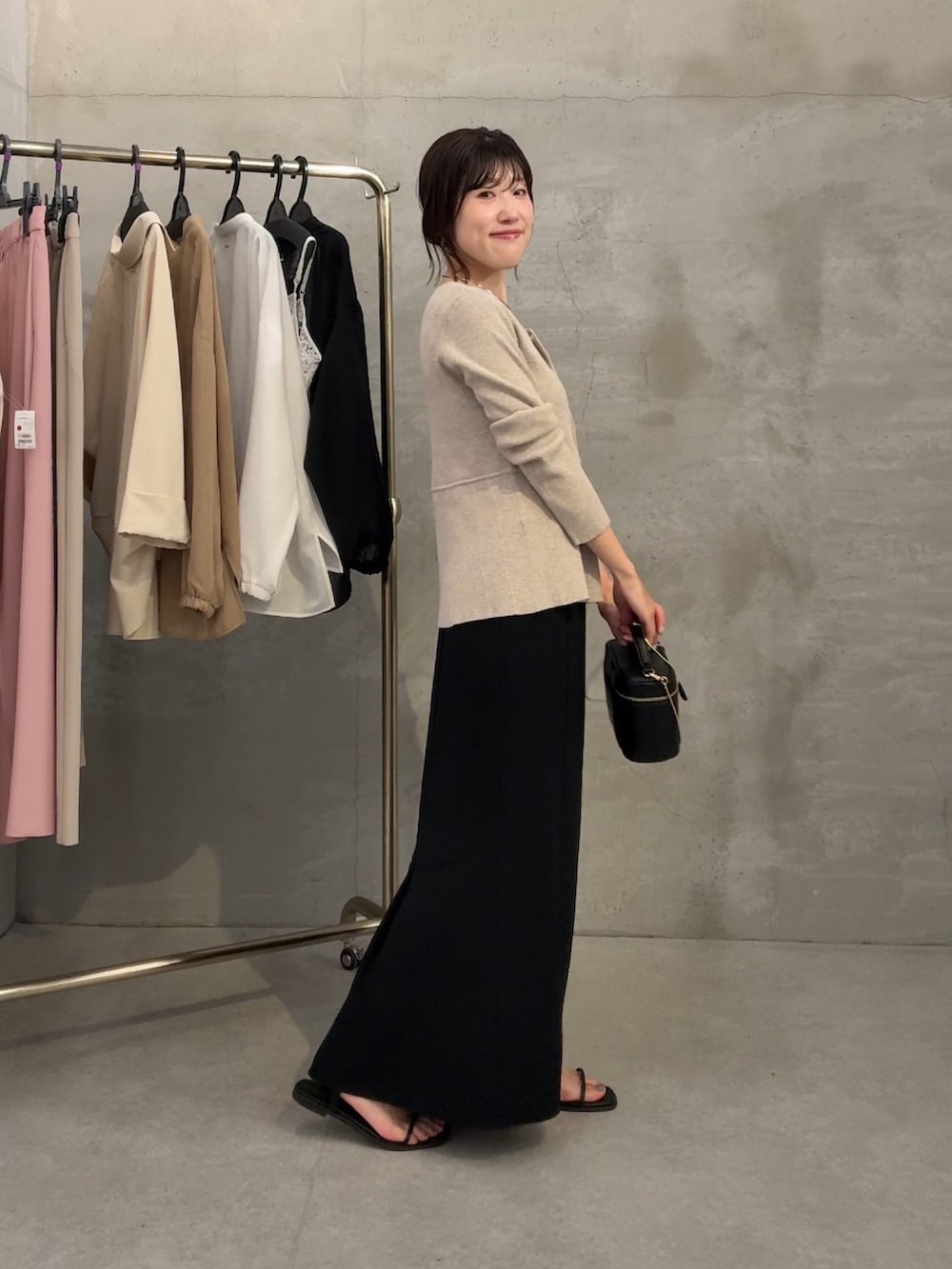 ベージュ系のカーディガン/ボレロ、ブラック系のスカート、ブラック系のショルダーバッグを着用したレディースの春コーディネートの4枚目の写真