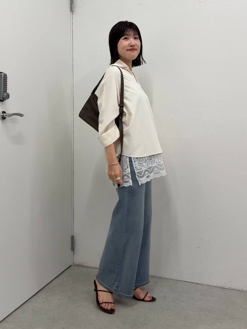 ホワイト系のシャツ/ブラウス、ホワイト系のキャミソール、ブルー系のデニムパンツを着用したレディースの春コーディネートの4枚目の写真