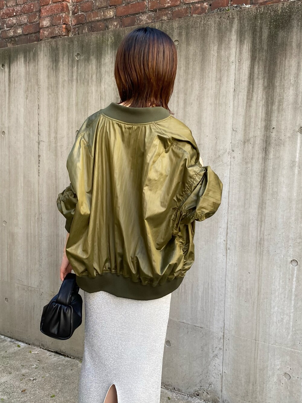 グリーン系のMA-1、ブラック系のキャミソール、ブラック系のショルダーバッグを着用したレディースの夏コーディネートの5枚目の写真