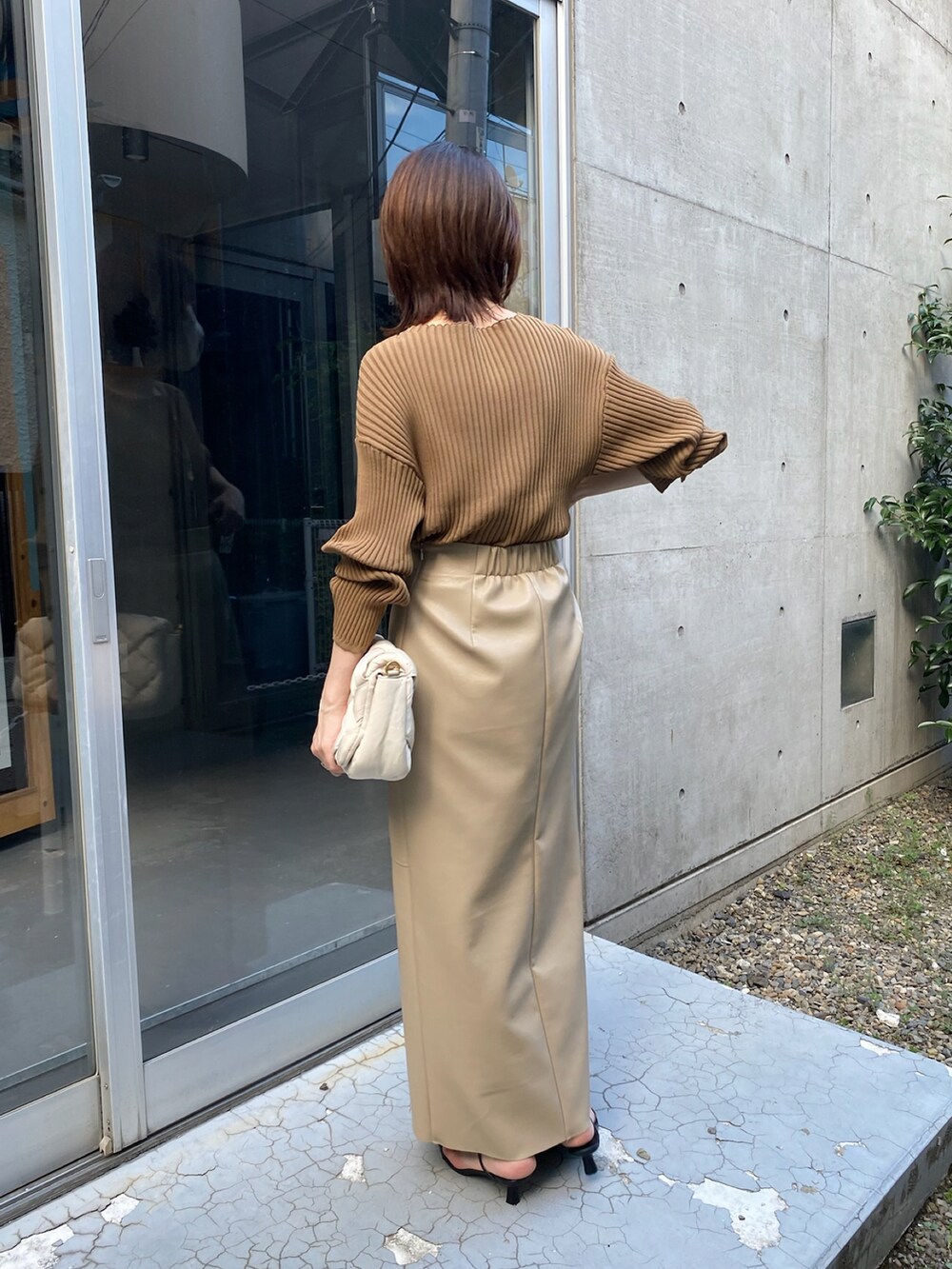 ホワイト系のショルダーバッグ、ベージュ系のスカートを着用したレディースの秋コーディネートの5枚目の写真