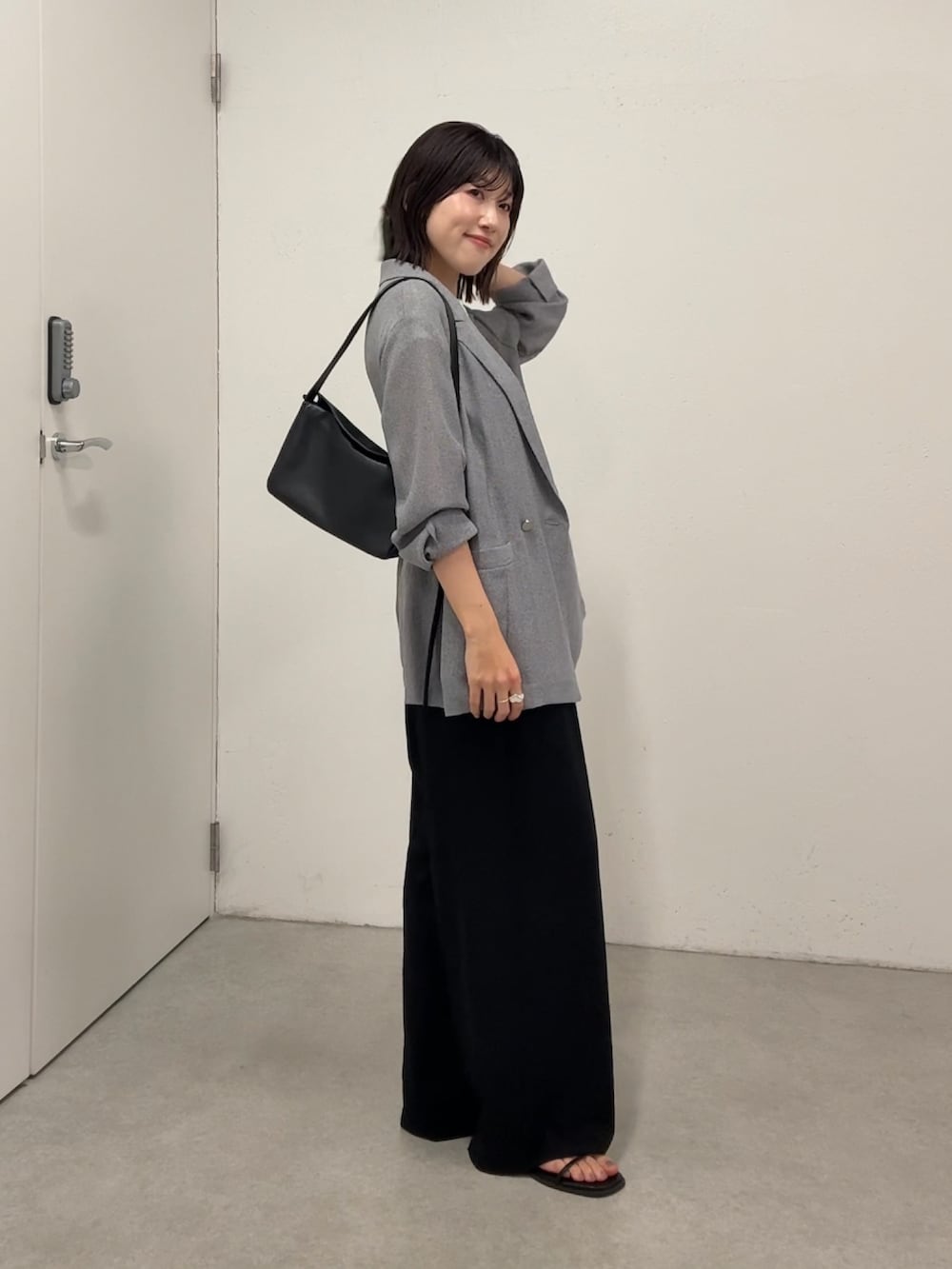 ホワイト系のTシャツ/カットソー、ブラック系のサンダル、グレー系のテーラードジャケットを着用したレディースの春コーディネートの3枚目の写真