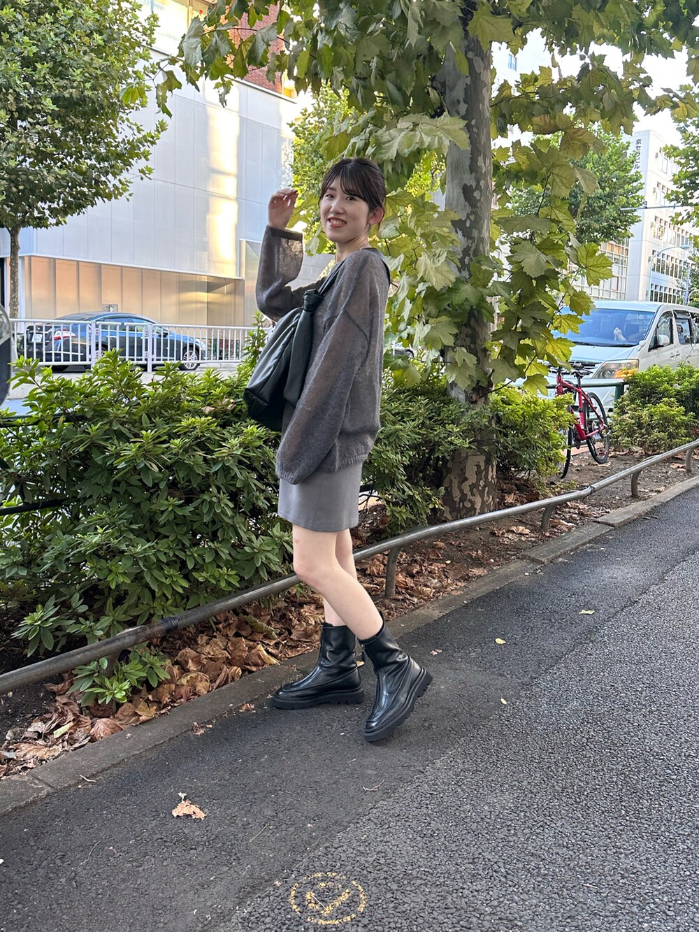 ブラック系のブーツ、ブルー系のニット/セーター、グレー系のスカートを着用したレディースの秋コーディネートの2枚目の写真