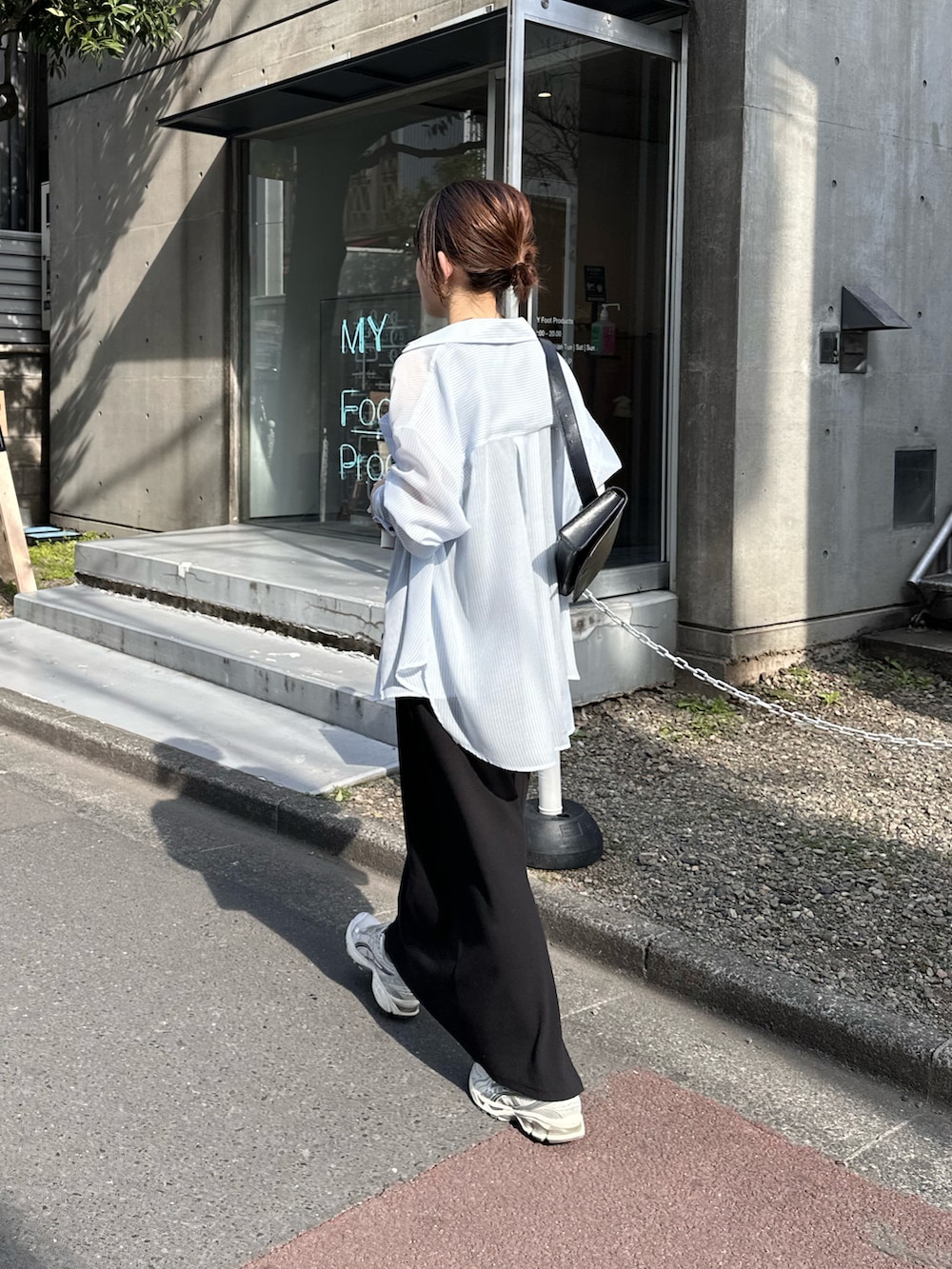 ブラック系のワンピース、ブルー系のシャツ/ブラウス、ブラック系のバッグを着用したレディースの春コーディネートの2枚目の写真