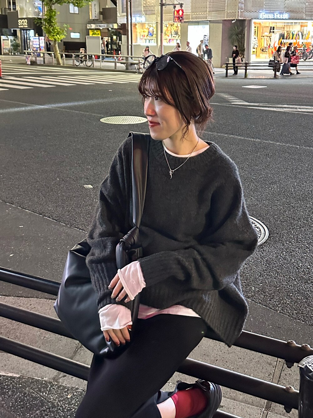 グレー系のニット/セーター、ブラック系のスカート、ホワイト系のTシャツ/カットソーを着用したレディースの秋コーディネートの3枚目の写真