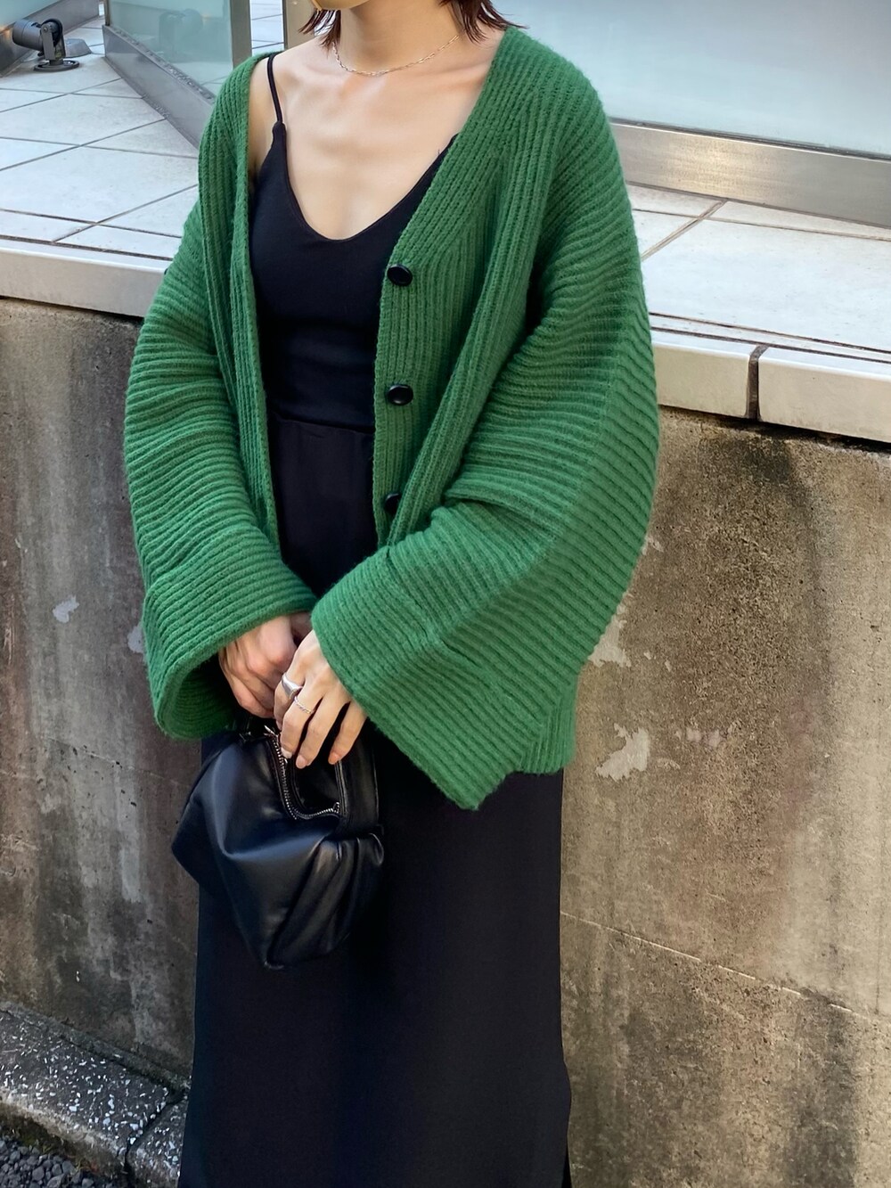 ブラック系のキャミソール、グリーン系のカーディガン/ボレロ、グリーン系のショルダーバッグを着用したレディースの夏コーディネートの2枚目の写真
