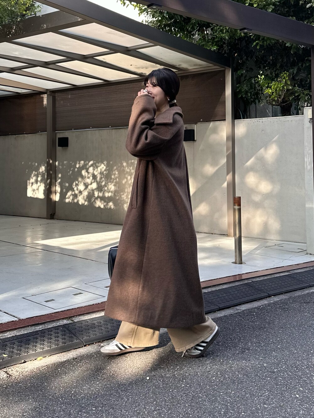 ブラック系のボストンバッグ、グレー系のその他アウター、ブルー系のデニムパンツを着用したレディースの秋コーディネートの3枚目の写真