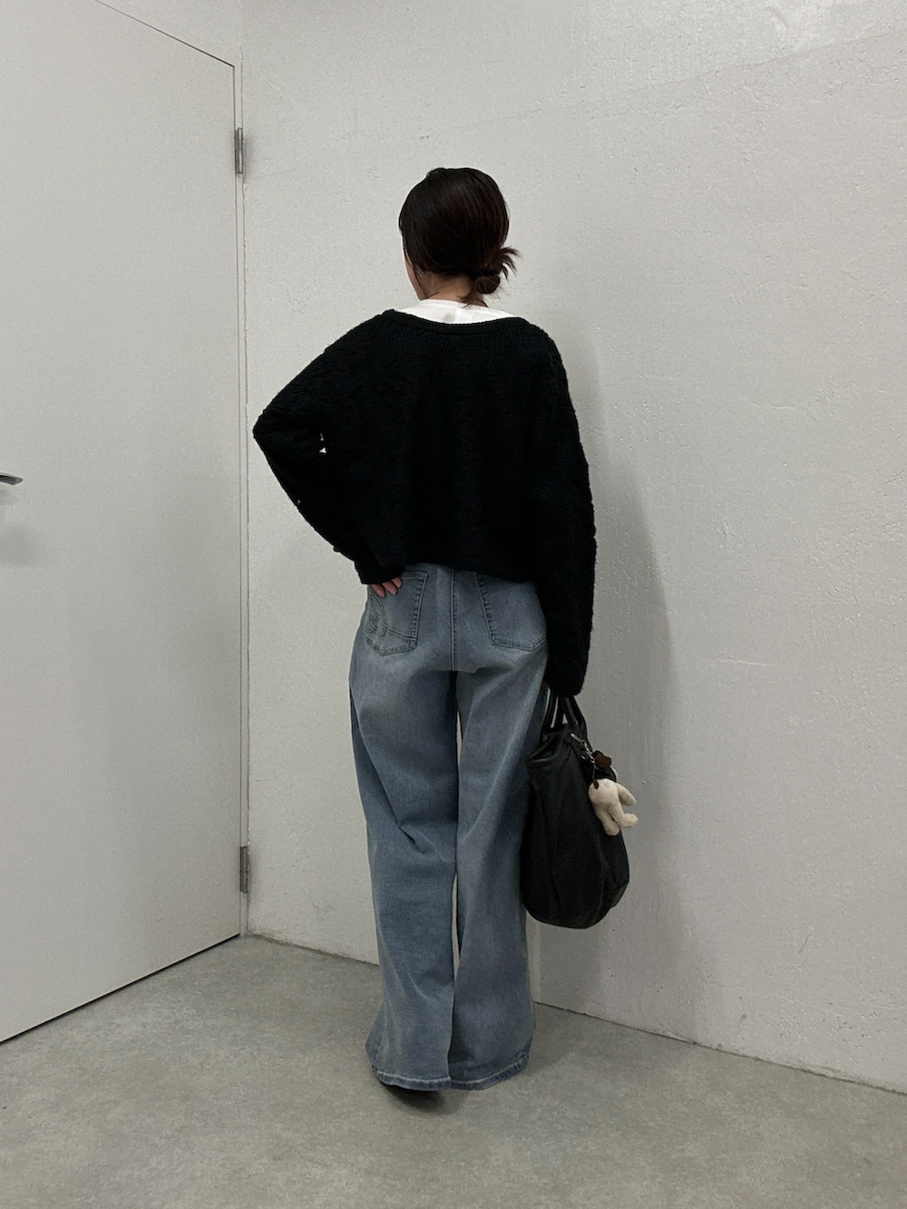 ブラック系のカーディガン/ボレロ、ブルー系のデニムパンツ、ホワイト系のシャツ/ブラウスを着用したレディースの冬コーディネートの3枚目の写真