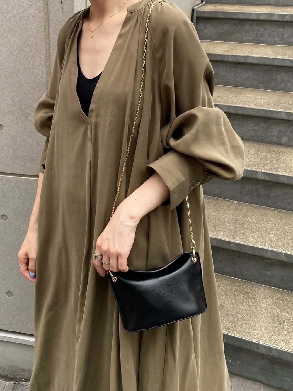 グリーン系のワンピース、ブラック系のブーツ、ブラック系のトートバッグを着用したレディースの夏コーディネートの5枚目の写真