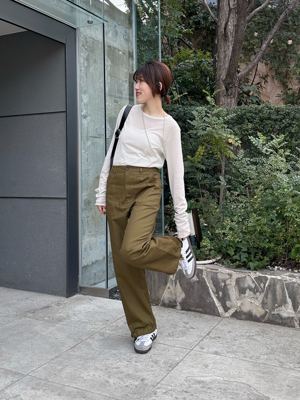 ホワイト系のTシャツ/カットソー、グリーン系のカーゴパンツ、ブラック系のバッグを着用したレディースの春コーディネートの3枚目の写真